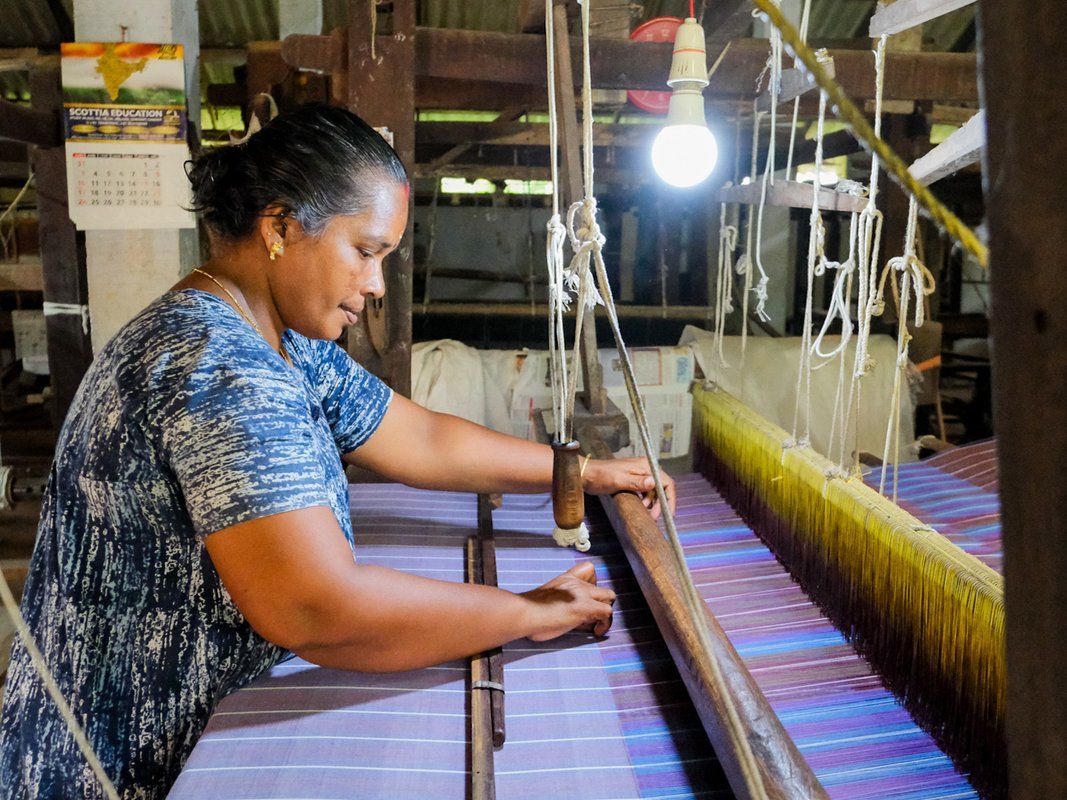 A weaver working at a wooden handloom at Chengamanad.